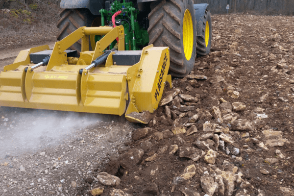Le broyeur de pierres BM 600, attelé par un tracteur, travaille dans un champ avec le résultat avant et après