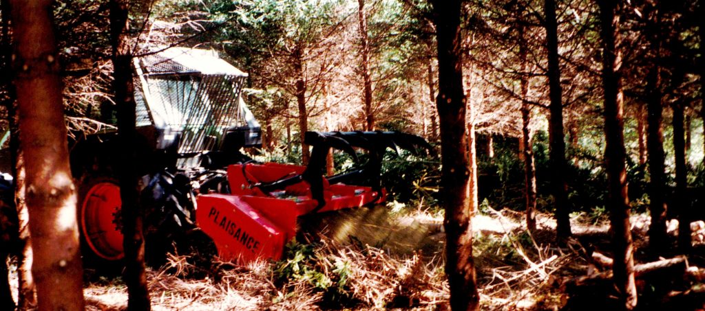Le broyeur forestier Plaisance est attelé à un tracteur et broie en forêt